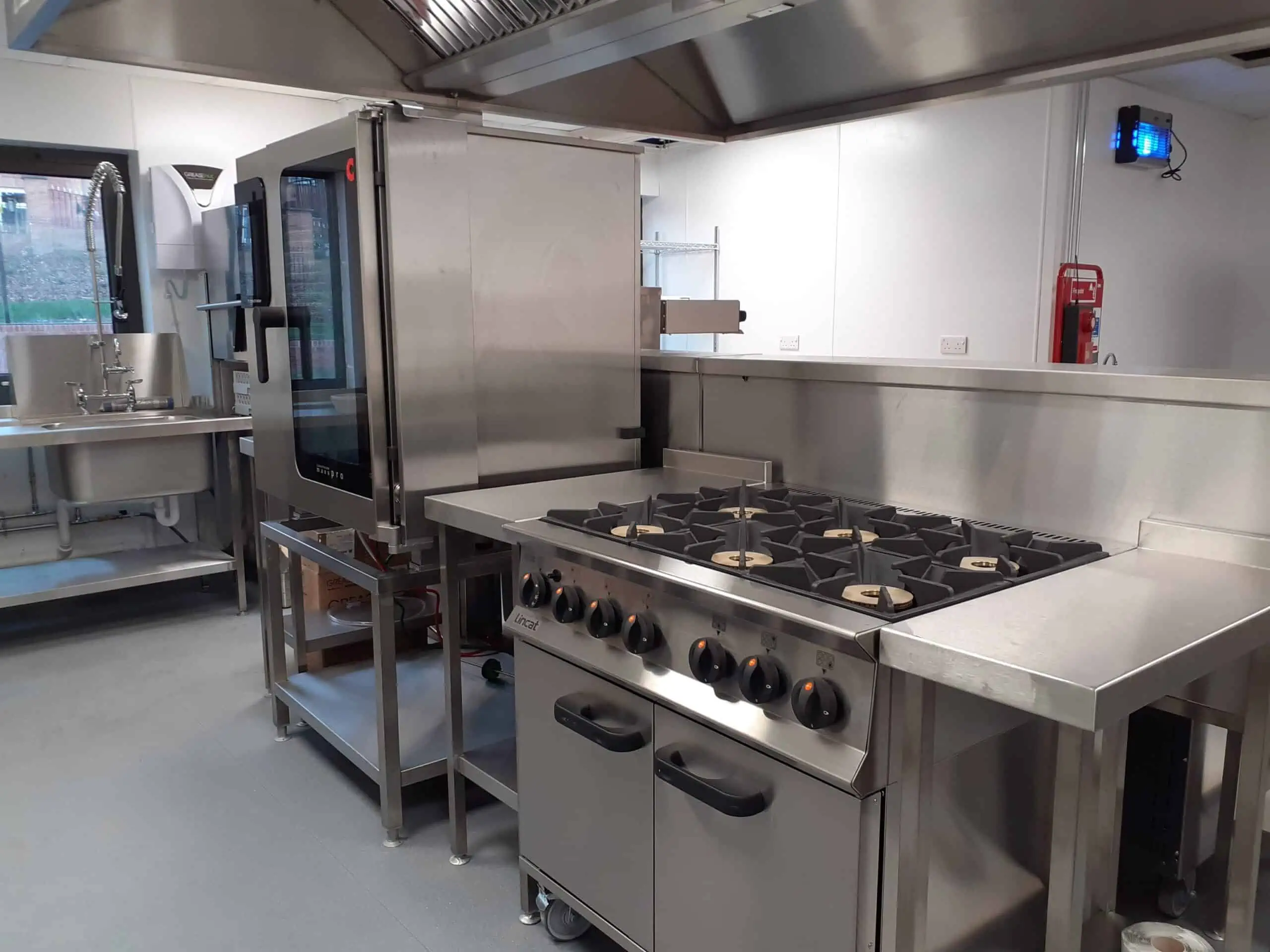 Fully installed bespoke catering equipment including convection oven, washup sink and gas top oven.